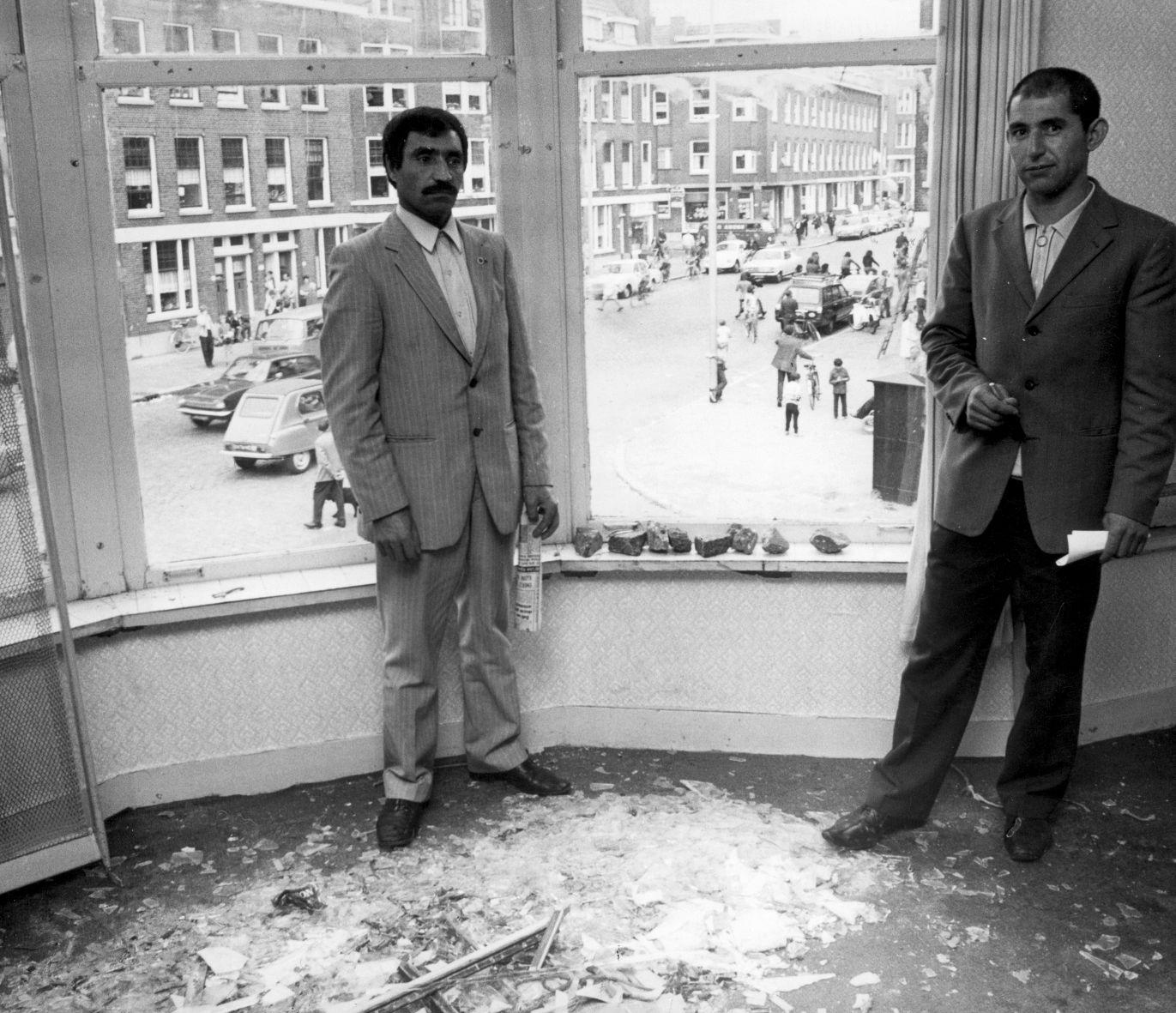 Rellen Afrikaanderbuurt: Turkse gastarbeiders temidden van ravage van glasscherven in een pension in de buurt, waar de ramen met talloze stenen, -een klein gedeelte ligt in de vensterbank-, zijn ingegooid, Rotterdam, Nederland 15 augustus 1972.